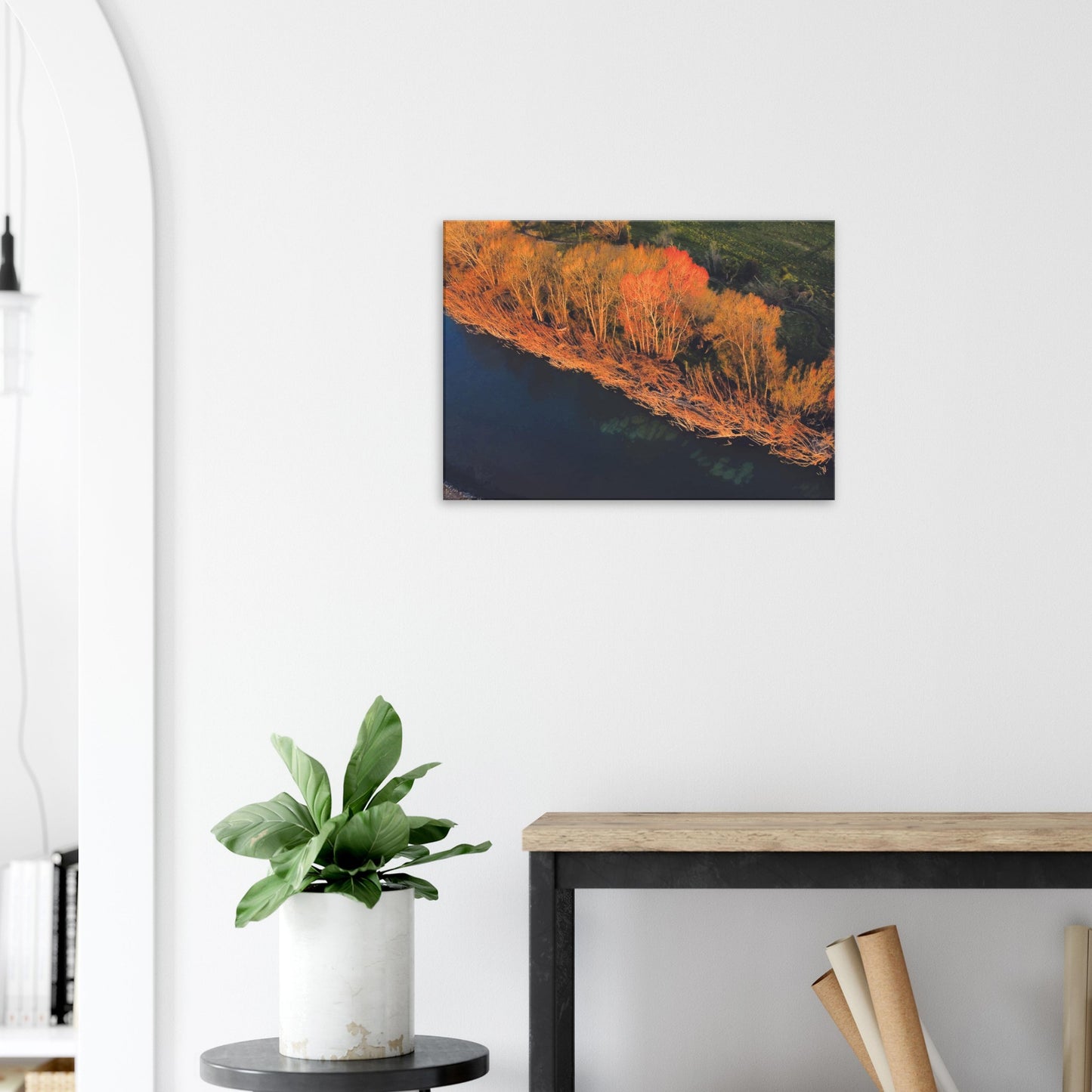 Aerial artwork of autumn trees glowing orange beside a deep blue New Zealand river, full of bold contrast and colour.