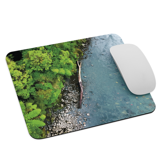 Resting Place mouse pad with aerial artwork of river rocks, green bush, and driftwood in a New Zealand stream.