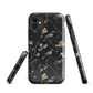 Dark phone case with blackbirds and gold blossoms on black branches.