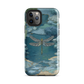 Nature-inspired phone case featuring a dragonfly over calm water with blue and green forest tones.