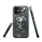 Gothic phone case with a floral skull design in grey tones, featuring white blossoms and dark detailing.