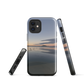 Phone case with tranquil lake scene at sunrise and distant hills.