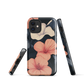 Phone case with coral hibiscus flowers and ivory blooms on dark background