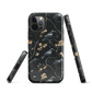 Dark phone case with blackbirds and gold blossoms on black branches.