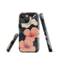 Phone case with coral hibiscus flowers and ivory blooms on dark background