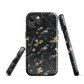 Dark phone case with blackbirds and gold blossoms on black branches.