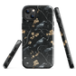 Dark phone case with blackbirds and gold blossoms on black branches.