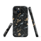 Dark phone case with blackbirds and gold blossoms on black branches.