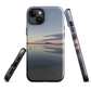 Phone case with tranquil lake scene at sunrise and distant hills.
