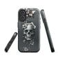Gothic phone case with a floral skull design in grey tones, featuring white blossoms and dark detailing.