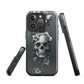 Gothic phone case with a floral skull design in grey tones, featuring white blossoms and dark detailing.