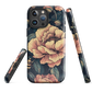 Phone case with vintage-style pink roses and bees on dark background, floral New Zealand artwork.