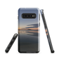 Phone case with tranquil lake scene at sunrise and distant hills.