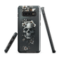 Gothic phone case with a floral skull design in grey tones, featuring white blossoms and dark detailing.