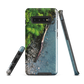Resting Place phone case with aerial artwork of river rocks, green bush, and driftwood in a New Zealand stream.