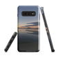 Phone case with tranquil lake scene at sunrise and distant hills.