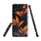 Phone case with bold orange bird of paradise flowers on dark background.