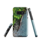 Resting Place phone case with aerial artwork of river rocks, green bush, and driftwood in a New Zealand stream.