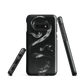 Phone case with detailed black python design on dark background.