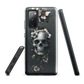 Gothic phone case with a floral skull design in grey tones, featuring white blossoms and dark detailing.