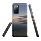 Phone case with tranquil lake scene at sunrise and distant hills.