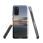 Phone case with tranquil lake scene at sunrise and distant hills.