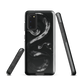 Phone case with detailed black python design on dark background.