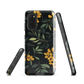 NZ Kowhai phone case with native yellow floral and green leaves on black background by designer Ben Hart.