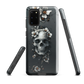 Gothic phone case with a floral skull design in grey tones, featuring white blossoms and dark detailing.