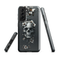 Gothic phone case with a floral skull design in grey tones, featuring white blossoms and dark detailing.