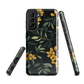 NZ Kowhai phone case with native yellow floral and green leaves on black background by designer Ben Hart.