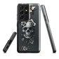 Gothic phone case with a floral skull design in grey tones, featuring white blossoms and dark detailing.