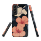 Phone case with coral hibiscus flowers and ivory blooms on dark background