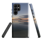 Phone case with tranquil lake scene at sunrise and distant hills.