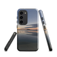 Phone case with tranquil lake scene at sunrise and distant hills.