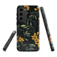 NZ Kowhai phone case with native yellow floral and green leaves on black background by designer Ben Hart.