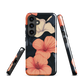 Phone case with coral hibiscus flowers and ivory blooms on dark background
