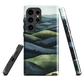 Phone case with layered mountain and forest landscape in blue and green hues